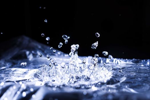 Water drops splashing on acoustic membrane. A lot of drops in air. High frequency of sound waves. Water cloud small drops. Frozen time shot. 