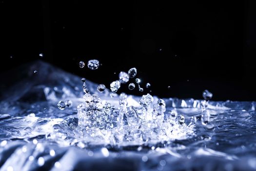 Water drops splashing on acoustic membrane. A lot of drops in air. High frequency of sound waves. Water cloud small drops. Frozen time shot.
