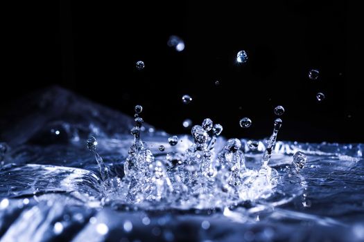 Water drops splashing on acoustic membrane. A lot of drops in air. High frequency of sound waves. Water cloud small drops. Frozen time shot. 