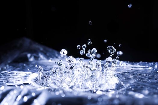 Water drops splashing on acoustic membrane. A lot of drops in air. High frequency of sound waves. Water cloud small drops. Frozen time shot.