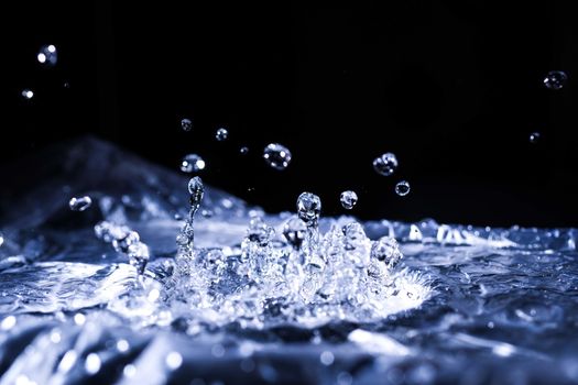 Water drops splashing on acoustic membrane. A lot of drops in air. High frequency of sound waves. Water cloud small drops. Frozen time shot. 