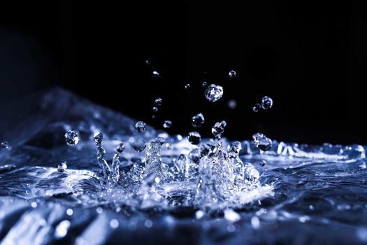 Water drops splashing on acoustic membrane. A lot of drops in air. High frequency of sound waves. Water cloud small drops. Frozen time shot.