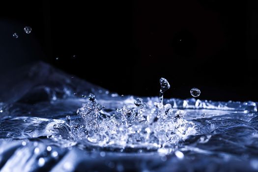 Water drops splashing on acoustic membrane. A lot of drops in air. High frequency of sound waves. Water cloud small drops. Frozen time shot.