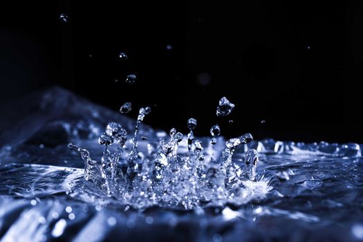 Water drops splashing on acoustic membrane. A lot of drops in air. High frequency of sound waves. Water cloud small drops. Frozen time shot. 