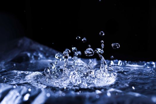 Water drops splashing on acoustic membrane. A lot of drops in air. High frequency of sound waves. Water cloud small drops. Frozen time shot. 