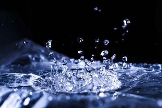 Water drops splashing on acoustic membrane. A lot of drops in air. High frequency of sound waves. Water cloud small drops. Frozen time shot. 