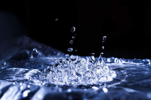 Water drops splashing on acoustic membrane. A lot of drops in air. High frequency of sound waves. Water cloud small drops. Frozen time shot.