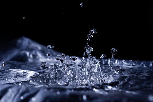 Water drops splashing on acoustic membrane. A lot of drops in air. High frequency of sound waves. Water cloud small drops. Frozen time shot. 