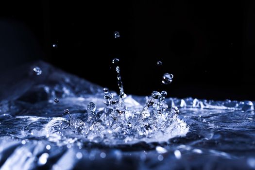 Water drops splashing on acoustic membrane. A lot of drops in air. High frequency of sound waves. Water cloud small drops. Frozen time shot.