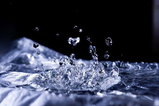 Water drops splashing on acoustic membrane. A lot of drops in air. High frequency of sound waves. Water cloud small drops. Frozen time shot.