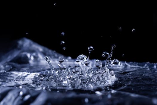 Water drops splashing on acoustic membrane. A lot of drops in air. High frequency of sound waves. Water cloud small drops. Frozen time shot.