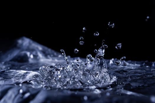 Water drops splashing on acoustic membrane. A lot of drops in air. High frequency of sound waves. Water cloud small drops. Frozen time shot. 