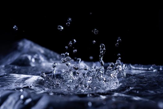 Water drops splashing on acoustic membrane. A lot of drops in air. High frequency of sound waves. Water cloud small drops. Frozen time shot. 