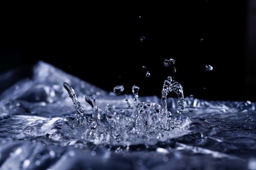 Water drops splashing on acoustic membrane. A lot of drops in air. High frequency of sound waves. Water cloud small drops. Frozen time shot. 