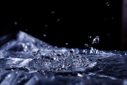 Water drops splashing on acoustic membrane. A lot of drops in air. High frequency of sound waves. Water cloud small drops. Frozen time shot. 