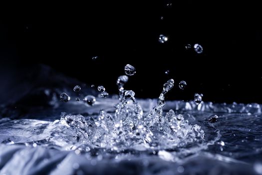 Water drops splashing on acoustic membrane. A lot of drops in air. High frequency of sound waves. Water cloud small drops. Frozen time shot. 