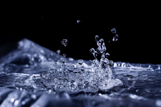 Water drops splashing on acoustic membrane. A lot of drops in air. High frequency of sound waves. Water cloud small drops. Frozen time shot. 
