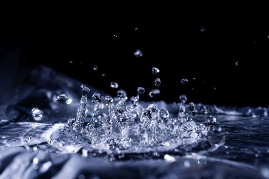 Water drops splashing on acoustic membrane. A lot of drops in air. High frequency of sound waves. Water cloud small drops. Frozen time shot.