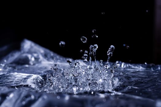Water drops splashing on acoustic membrane. A lot of drops in air. High frequency of sound waves. Water cloud small drops. Frozen time shot.