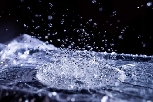 Water drops splashing on acoustic membrane. A lot of drops in air. High frequency of sound waves. Water cloud small drops. Frozen time shot.