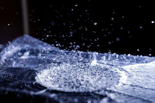 Water drops splashing on acoustic membrane. A lot of drops in air. High frequency of sound waves. Water cloud small drops. Frozen time shot.