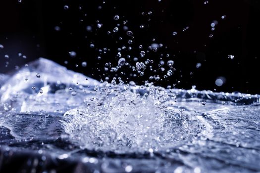 Water drops splashing on acoustic membrane. A lot of drops in air. High frequency of sound waves. Water cloud small drops. Frozen time shot.