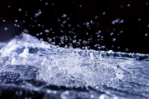 Water drops splashing on acoustic membrane. A lot of drops in air. High frequency of sound waves. Water cloud small drops. Frozen time shot.