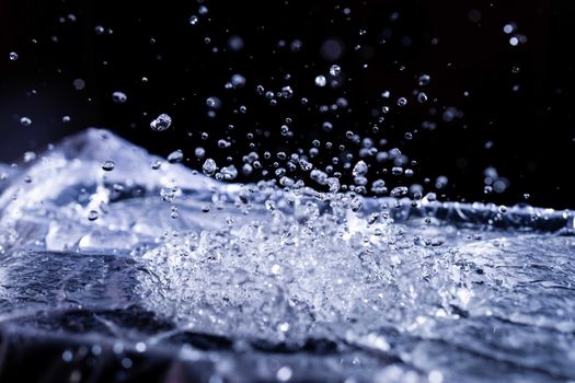 Water drops splashing on acoustic membrane. A lot of drops in air. High frequency of sound waves. Water cloud small drops. Frozen time shot.