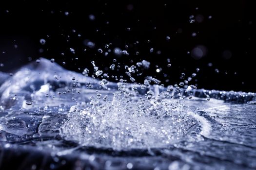 Water drops splashing on acoustic membrane. A lot of drops in air. High frequency of sound waves. Water cloud small drops. Frozen time shot.