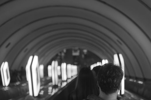 the man on the escalator turned his back. Black and white photos, the lamps are arranged in rows. Photo shows loneliness in society