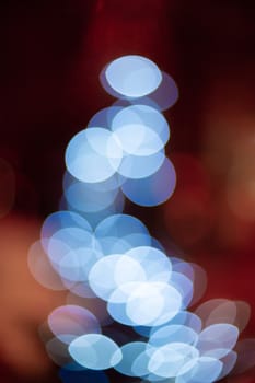 Outdoor Christmas tree defocused light. White lights in tree is blurred. Big beautiful curly bokeh