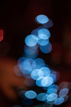 Outdoor Christmas tree defocused light. White lights in tree is blurred. Big beautiful curly bokeh