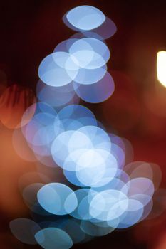 Outdoor Christmas tree defocused light. White lights in tree is blurred. Big beautiful curly bokeh