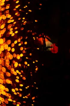 Vertical Christmas garland wall on glass window. Light is orange and defocused. Blurred background, new year mood.