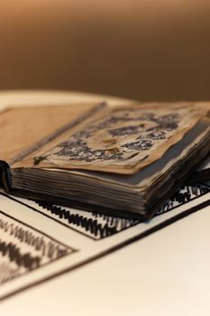 Handmade magic notebook with tower symbol on cover. Leather cover and handmade sheets inside. Notebook have 12 signs of the zodiac on first page. Very blurred background with soft focus on notebook.