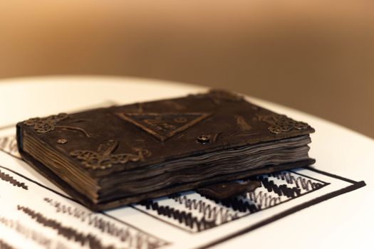 Handmade magic notebook with tower symbol on cover. Leather cover and handmade sheets inside. Very blurred background with soft focus on notebook.