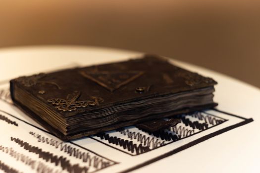 Handmade magic notebook with tower symbol on cover. Leather cover and handmade sheets inside. Very blurred background with soft focus on notebook.