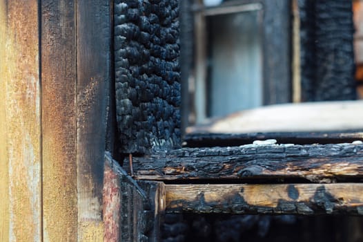 The wood window after seroius fire. The wooden building after fire. A bred is very charred.