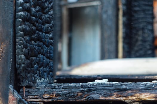 The wood window after seroius fire. The wooden building after fire. A bred is very charred.