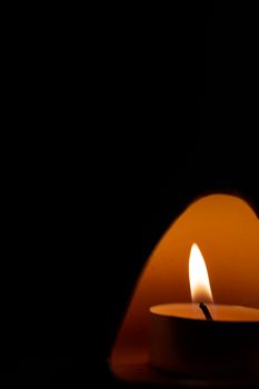 Underexposed low light photo of candle in aromatic lamp. Close-up view