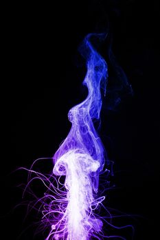 Column of vape clouds splash on black background. A lot of lines of smoke. Two colours fog is blue and purple. Stock isolated color smoke with spray boiling liquid.