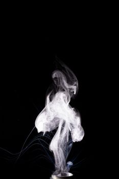 Vape steam column with spray boiling liquid. Stock photo isolated on black background.