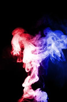 Column of vape clouds splash on black background. A lot of lines of smoke. Two colours fog is blue and red. Stock isolated color smoke with spray boiling liquid.