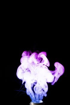 Vape clouds splash with two colours fog is blue and purple colour. Low light photo. Stock isolated on black background color smoke with spray boiling glycerine lines.