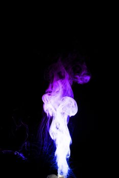 Dual colour vape steam column with spray boiling liquid. Blue and purple colour smoke. Stock photo isolated on black background.