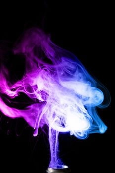 Vape clouds splash with two colours fog is blue and purple colour. Low light photo. Stock isolated on black background color smoke with spray boiling glycerine lines.