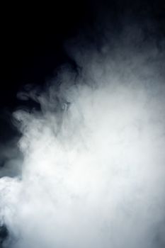 Сlouds of vape fog on black background. At right side thick smoke rising up. Vape culture and no smoking movement.