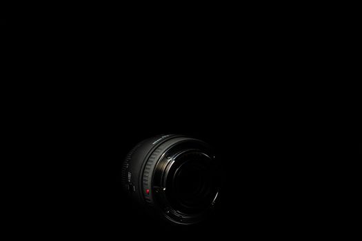 Underexposed photo of DSLR lens. Stock photo isolated on black background. Low light photo. A large depth of field.