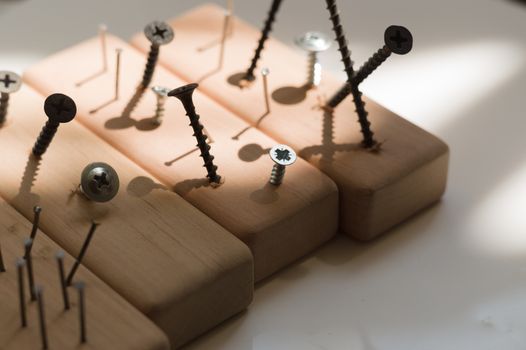 Learn the work with a screwdriver. Teaching to use tools. Conceptual photo. Learning to use screwdriver and a hammer. Many screws and pins.