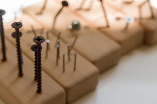 Learn the work with a screwdriver. Teaching to use tools. Conceptual photo. Learning to use screwdriver and a hammer. Many screws and pins.